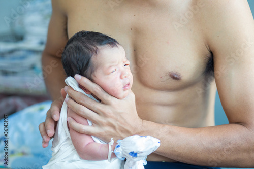 Beautiful young Asian father hold newborn baby boy with hand to help baby belch or Making burp after feeding