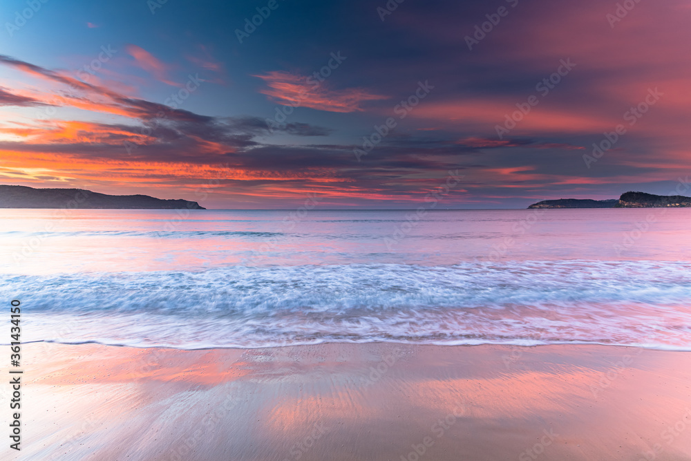 Sunrise at the Beach with Clouds and Colour reflections in the Sand