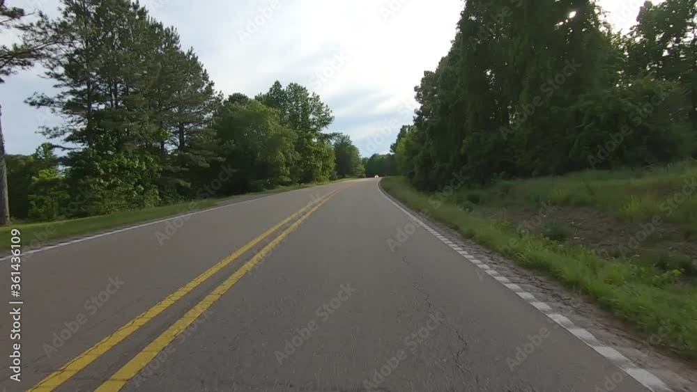 POV driving on a rural highway pasts trees and fields - Alabama, USA POV driving on a rural highway pasts trees and fields - Alabama, USA