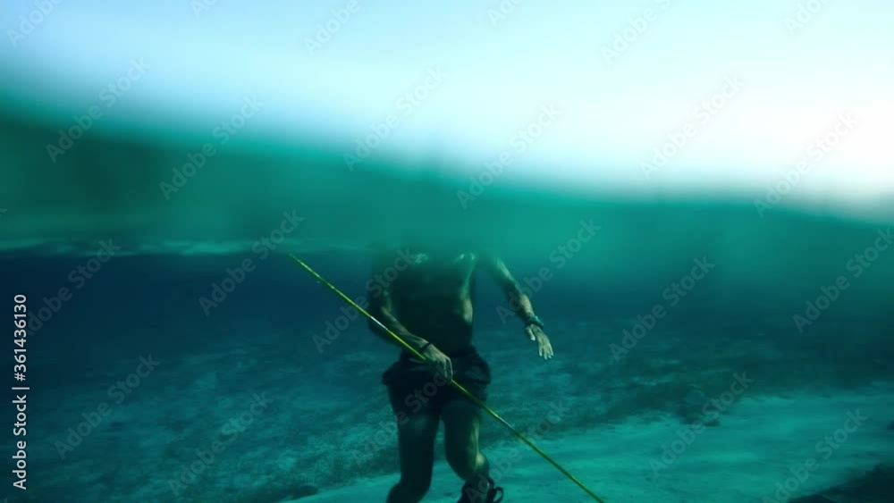 A spearfishing apnoea diver comes up to the surface near a underwater plane wrack