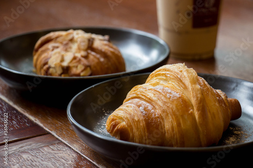Croissant on the wood table with coffee shop