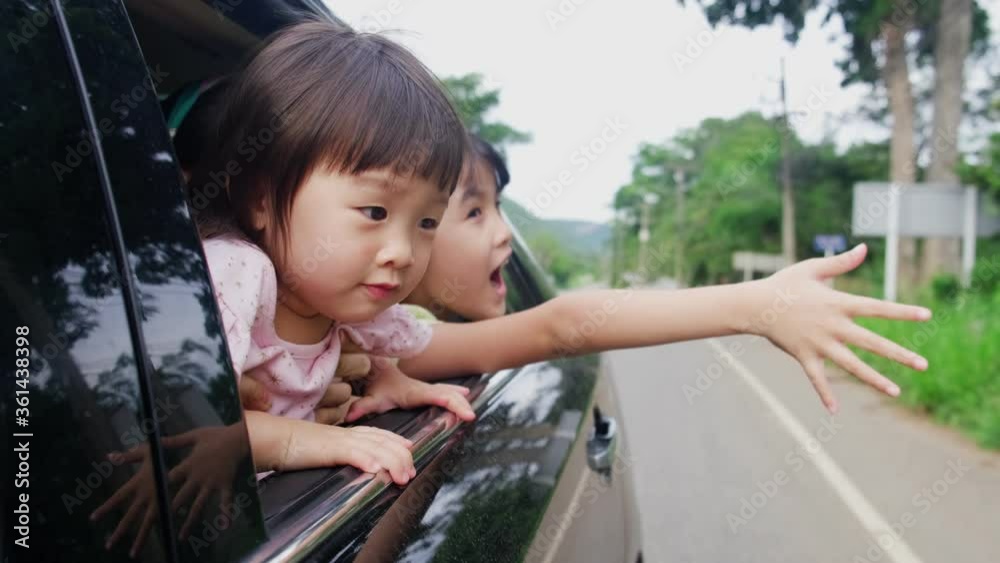 Asian family sit on back rear seat open car window to face air outside Asian family sit on back rear seat open car window to face air outside