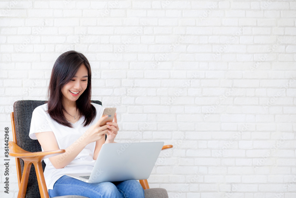 Young asian woman is freelance sitting using working on smartphone and laptop computer, free time of girl relax and cozy on phone with happy and comfort, business and technology, lifestyle concept. Young asian woman is freelance sitting using working on smartphone and laptop computer, free time of girl relax and cozy on phone with happy and comfort, business and technology, lifestyle concept.