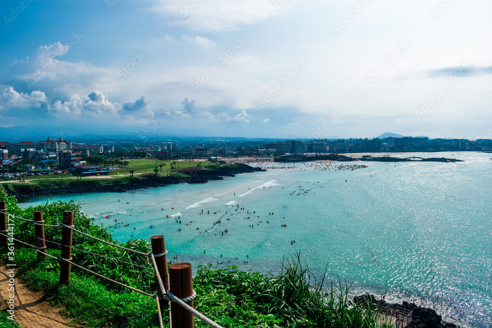 View of Hamdeok Beach on Jeju Island from atop small mountain. 