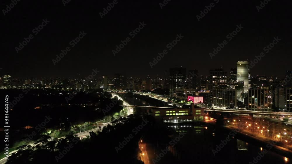Establishing shot of the skyline of São Paulo city by night. Drone traveling in approaching the Pinheiros River. Establishing shot of the skyline of São Paulo city by night. Drone traveling in approaching the Pinheiros River.