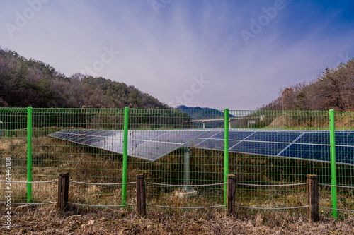 Solar panels behind green fence