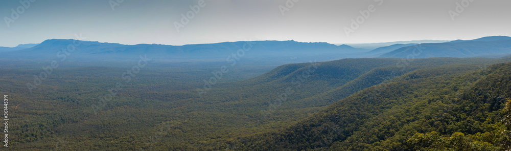 wide panorama showing the densely forested Grampians national park mountain range stretching off into the distance on a clear summer day, regional Victoria, Australia
