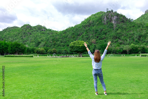 A woman standing in the grassland and mountains. Feel excited and happy on holiday. Vacation concept.