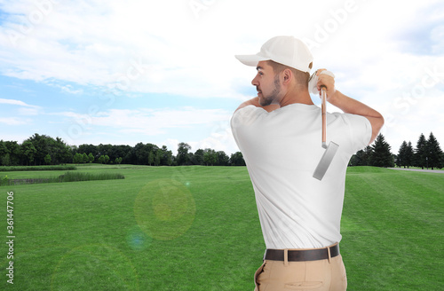 Young man playing golf on course with green grass. Space for design