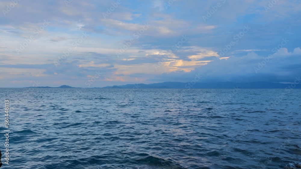 Sky with clouds above the ocean, calm water surface