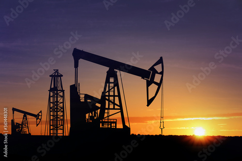 Fotografie, Obraz Silhouettes of crude oil pumps at sunset