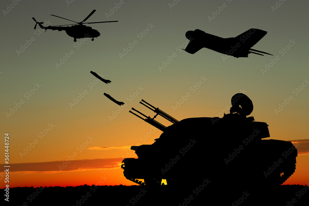 Silhouettes of different military machinery at sunset outdoors