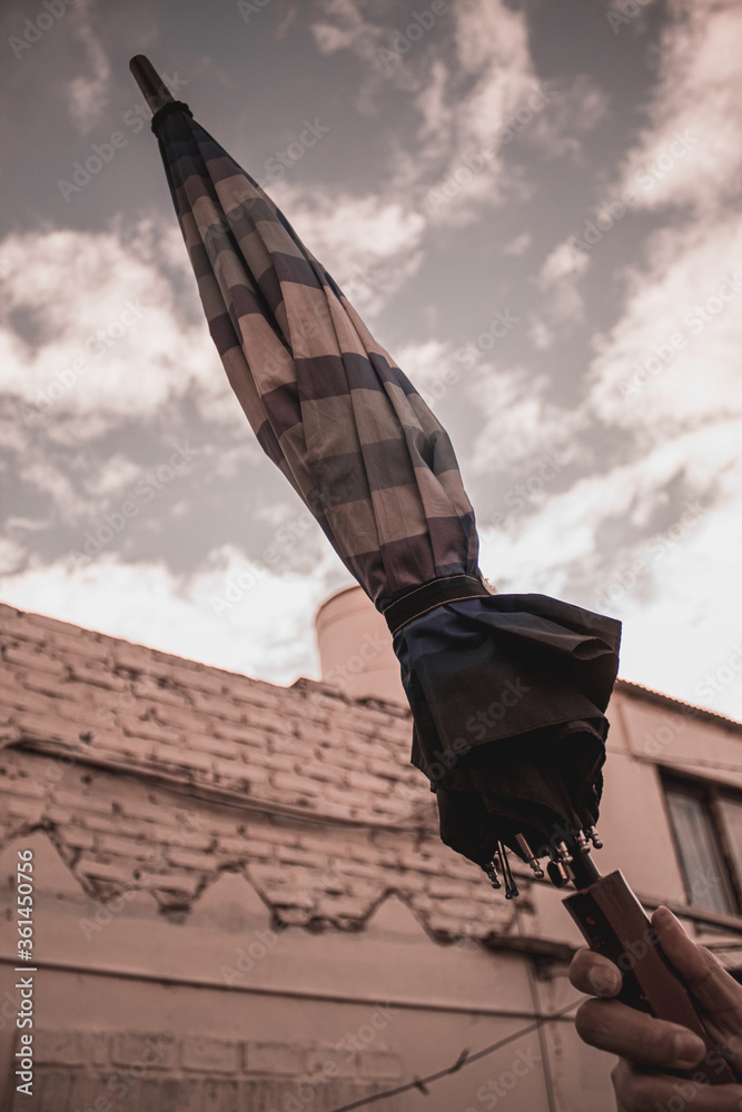 Obraz premium hands of a young person holding a closed umbrella
