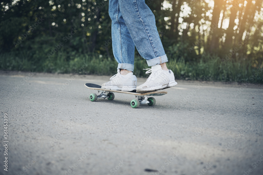 Guy rides skateboard on asphalt road in afternoon and sunlight Guy rides skateboard on asphalt road in afternoon and sunlight