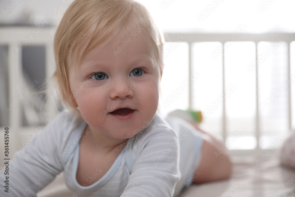 Adorable little baby lying in comfortable crib