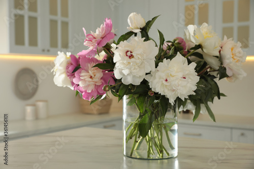 Bouquet of beautiful peonies on table in kitchen