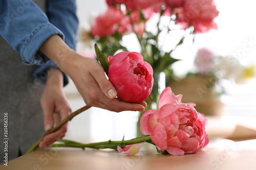 Fototapeta Naklejka Na Ścianę i Meble -  Florist making beautiful peony bouquet at table, closeup
