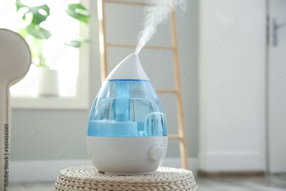 Modern air humidifier on wicker pouf indoors - obrazy, fototapety, plakaty 