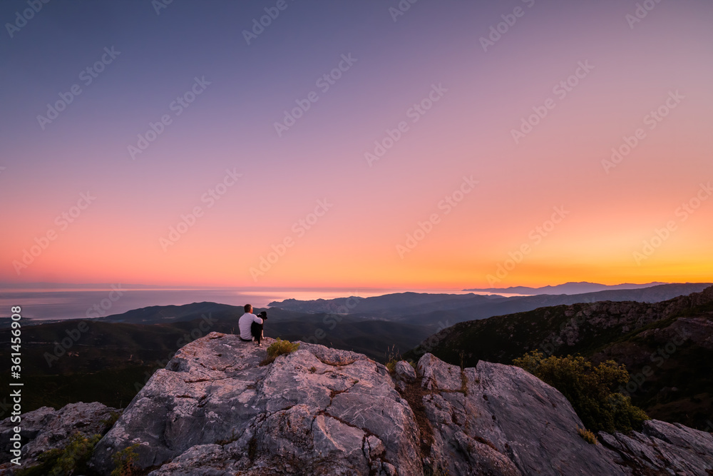 Naklejka premium Man and dog view Mediterranean in Corsica at sunrise