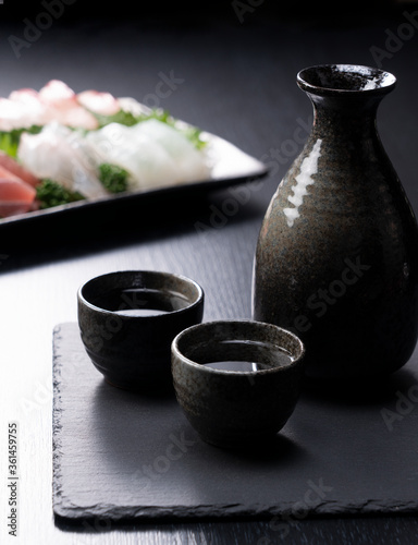 Sake and sashimi on a black background