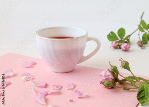  A Cup of morning tea with branches and rose petals on a pastel background, side view, close-up, place for the inscription-the concept of good morning and good mood.