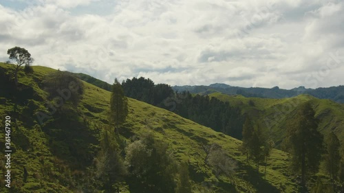 Grassy hills along Hwy 4 and the Mangawhero River on the North Island of New Zealand - Cloudy- Spring// Panning Shot photo