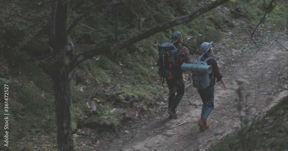 Young man and woman hiking in forest