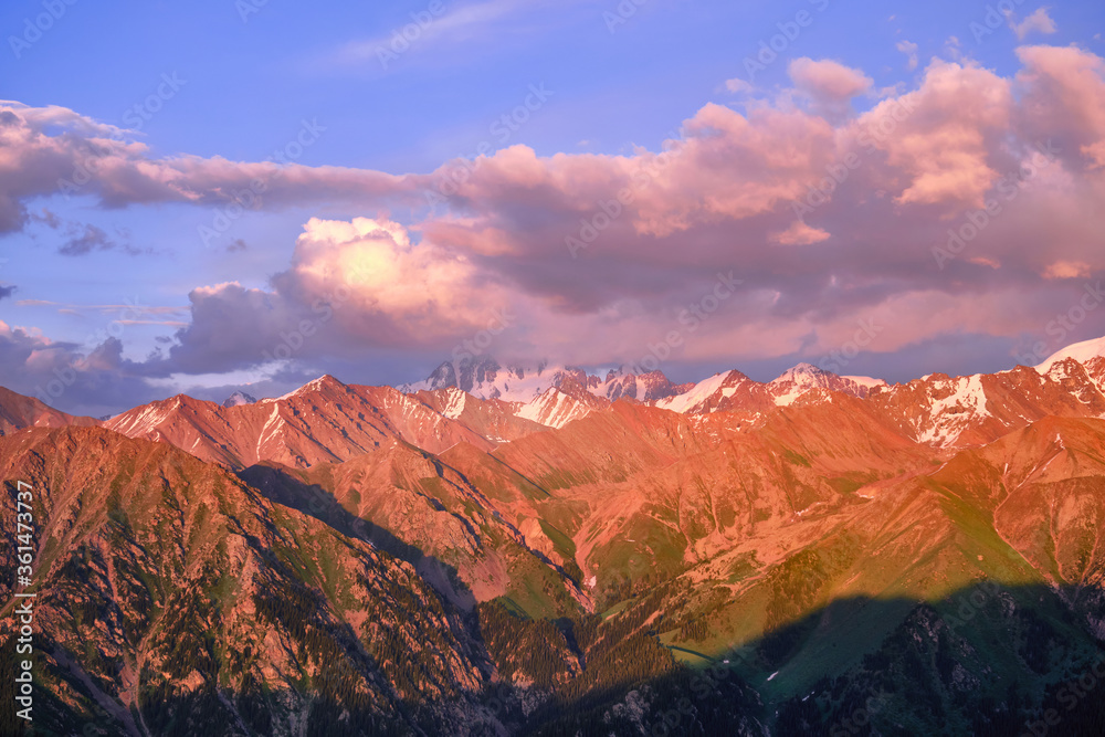 Grandiose mountain valley with ridges of snowy peaks at sunset