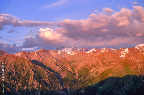 Grandiose mountain valley with ridges of snowy peaks at sunset