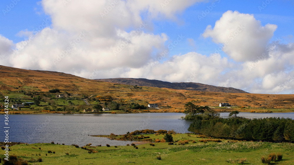 Irish landscape with a lake, puffy clouds, typical scene from Connemara