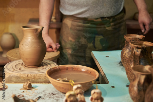 Process of making clay pot on a potter s wheel in workshop. Potter at work