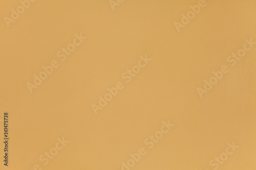 Dark yellow wall, texture, background. The building wall, painted with water-based paint. Smooth (flat) surface in yellow color with golden brown, flaxen and wheat tint or shade