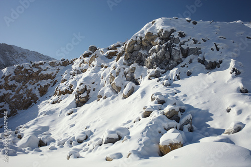 Rocky scree covered with snow in a winter sunny day in a stone quarry.