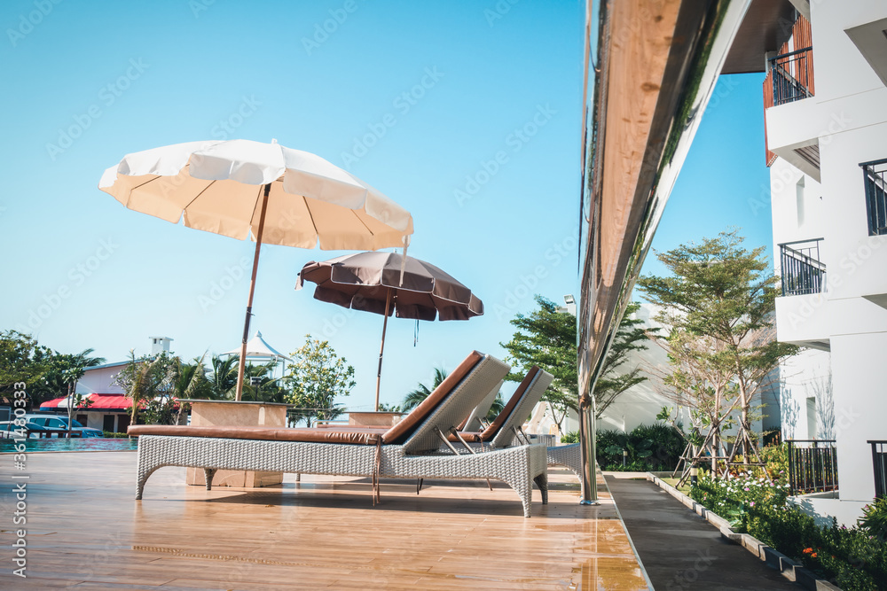 Luxury Swimming Pool and Relax Spa in Summer Vacation, Poolside With Beautiful Private Tropical Beach View. Holiday Relaxing at The Sea and Outdoor Leisure on Summer Season. Umbrella and Sunbeds Decor Luxury Swimming Pool and Relax Spa in Summer Vacation, Poolside With Beautiful Private Tropical Beach View. Holiday Relaxing at The Sea and Outdoor Leisure on Summer Season. Umbrella and Sunbeds Decor