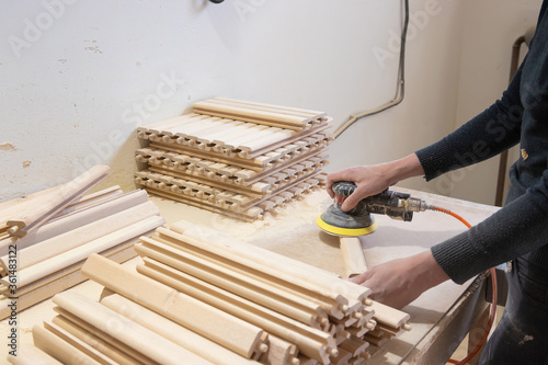 diligent female carpenter sanding wood at the workshop