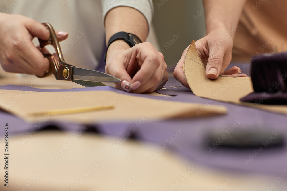 Workplace of seamstress. Dressmaker cuts textile on the sketch lines. female hand with the scissors cutting fabric. Workplace of seamstress. Dressmaker cuts textile on the sketch lines. female hand with the scissors cutting fabric.