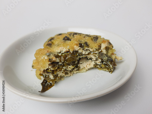 Rolade daun singkong, is a fried food from Indonesia. Made from cassava leaves, tofu and flour. Isolated in white background. photo