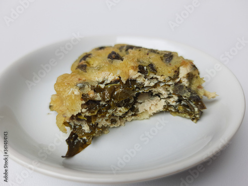 Rolade daun singkong, is a fried food from Indonesia. Made from cassava leaves, tofu and flour. Isolated in white background. photo