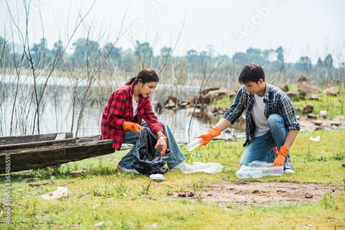 Men and women help each other to collect garbage.