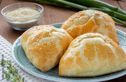 Delicious Uzbek samsa with meat and onions sprinkled with sesame on the table.