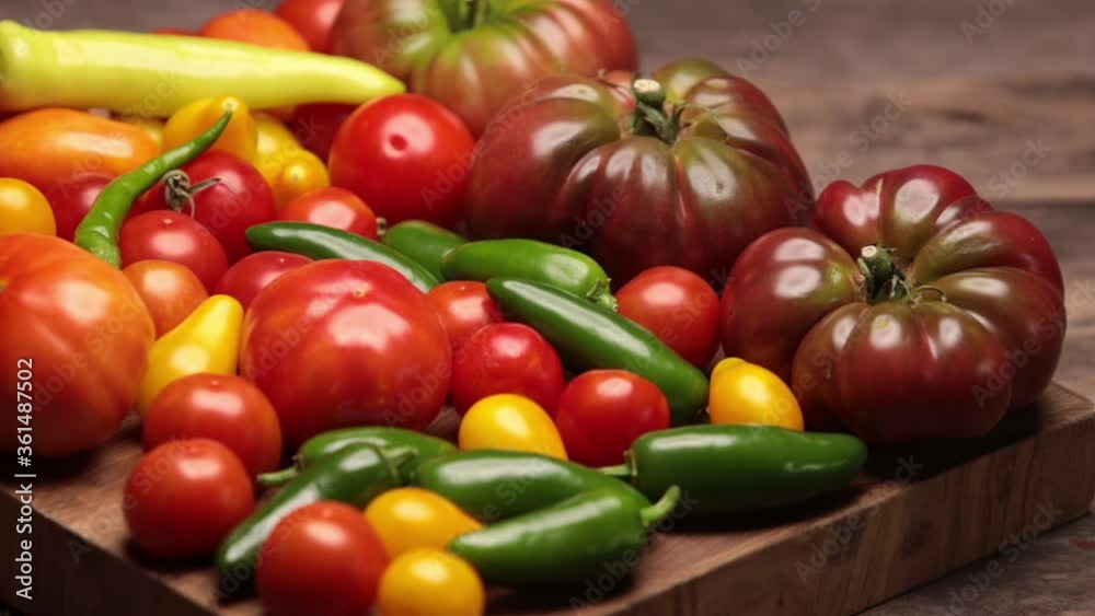 Flat lay on rustic aged pallet wood Cherokee purple tomato Jalapeno pepper red and yellow tomatoes cayenne and yellow pepper with hardwood cutting board. Flat lay on rustic aged pallet wood Cherokee purple tomato Jalapeno pepper red and yellow tomatoes cayenne and yellow pepper with hardwood cutting board.