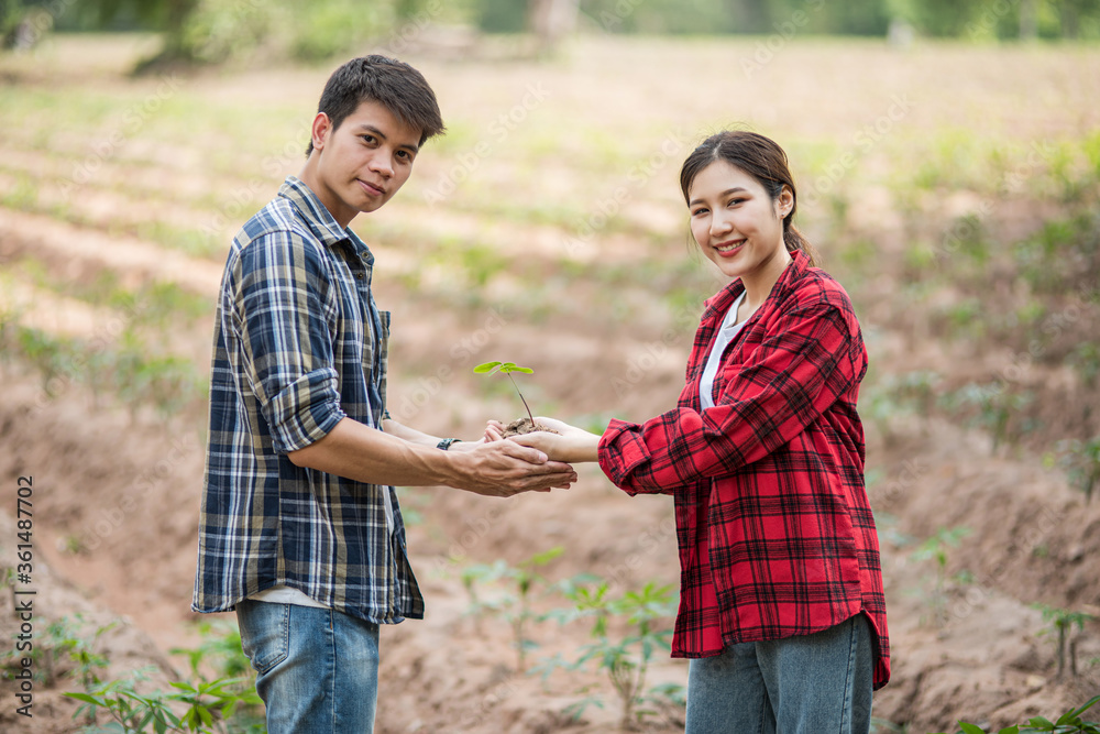 Men and women standing and holding saplings. Men and women standing and holding saplings.