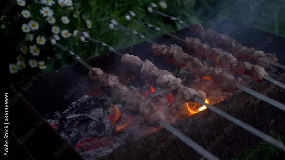 Pieces of pork meat strung on skewers are slowly fried in barbecue. Picnic in courtyard of a village house. BBQ cooking Pieces of pork meat strung on skewers are slowly fried in barbecue. Picnic in courtyard of a village house. BBQ cooking