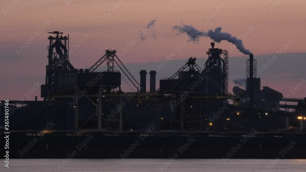Tata Steel in IJmuiden in the early morning with smoking industrial towers Tata Steel in IJmuiden in the early morning with smoking industrial towers