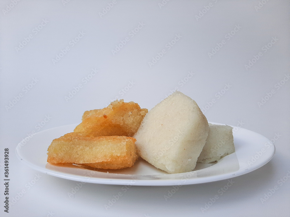 Jadah ketan, is a traditional snack from Indonesia. Made from sticky rice and grated coconut. Comparison before and after fried. On a white plate, isolated in white background Jadah ketan, is a traditional snack from Indonesia. Made from sticky rice and grated coconut. Comparison before and after fried. On a white plate, isolated in white background
