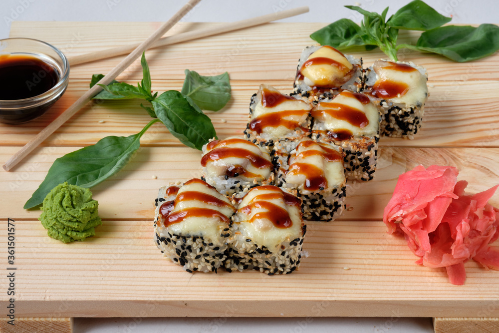 Japanese Sushi rolls with white and black sesames, chicken, cream cheese, white rice, wasabi, soy sauce and pickled ginger. Tasty and artistic food for restaurant or cafe menu.