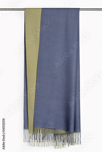 On a metal hanger, a gray-green scarf, cashmere stole. White background.
