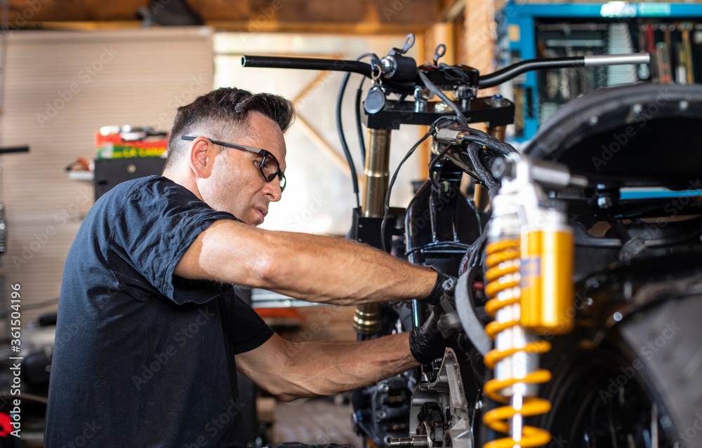 mechanic working on the repair of a motorcycle in the workshop mechanic working on the repair of a motorcycle in the workshop