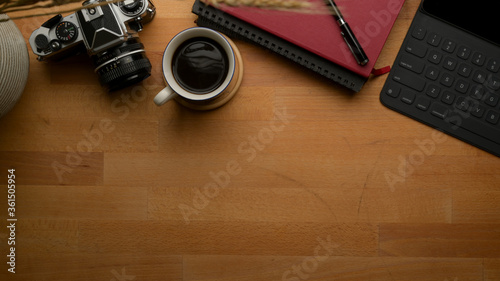 Photographer worktable with copy space with camera, tablet, schedule books, coffee cup and decoration