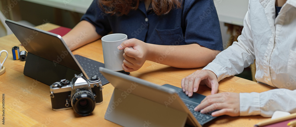 Cropped shot of two female partner working together with digital tablets and camera
